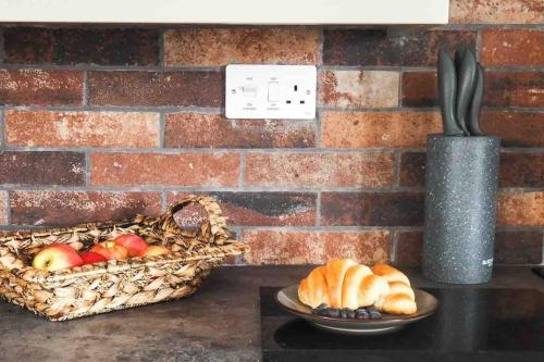 a basket of bread and a basket of fruit on a table at Large Cottage, Beach, Pubs Shops, Netflix, BBQ, Dog Friendly in Hunmanby