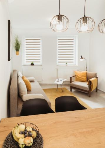 a living room with a table and a couch at Major11 apartman - Zsolnay negyed in Pécs