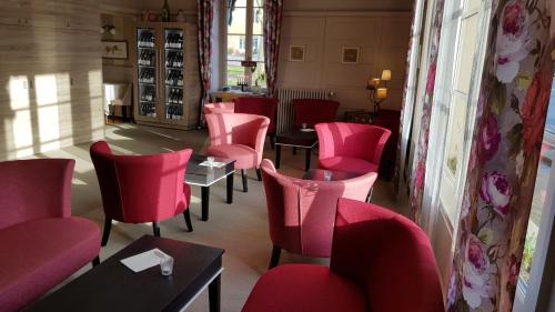 a room with pink chairs and tables in a restaurant at Hostellerie d'Héloïse Logis in Cluny