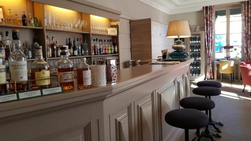 a bar with bottles of alcohol on the shelves at Hostellerie d'Héloïse Logis in Cluny