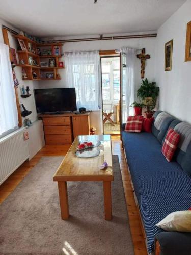 a living room with a blue couch and a coffee table at Kuća za odmor Sanja in Kupres