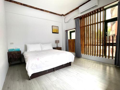 a bedroom with a bed and a large window at Haus 19 in Puli