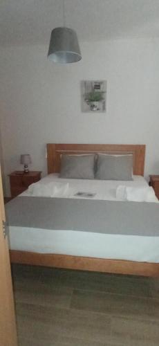 a bedroom with a large bed with a wooden frame at Casa do Meio in Alcofra