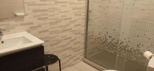 a bathroom with a glass shower and a sink at Casa do Meio in Alcofra