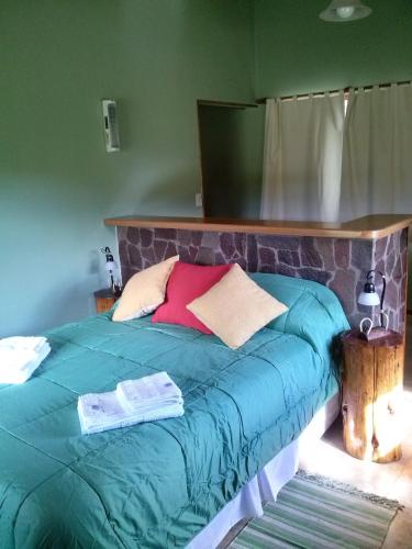 a bed with a blue comforter and pillows on it at KaiKen Lauquen in Trevelin