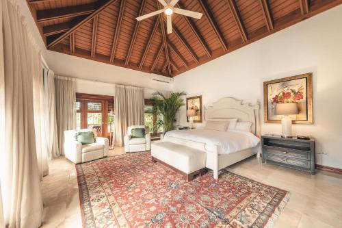 a bedroom with a bed and a chair and a rug at Maison Larimar-Walking Distance to the Marina at Casa de Campo in La Romana