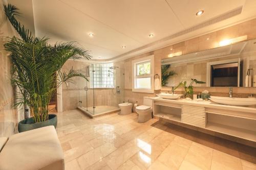 a large bathroom with two sinks and a shower at Maison Larimar-Walking Distance to the Marina at Casa de Campo in La Romana