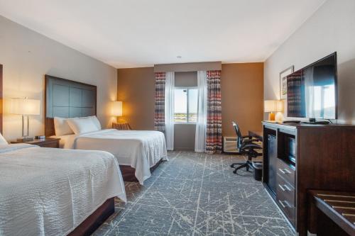 堪薩斯城的住宿－Orangewood Inn & Suites Kansas City Airport，酒店客房设有两张床和电视。