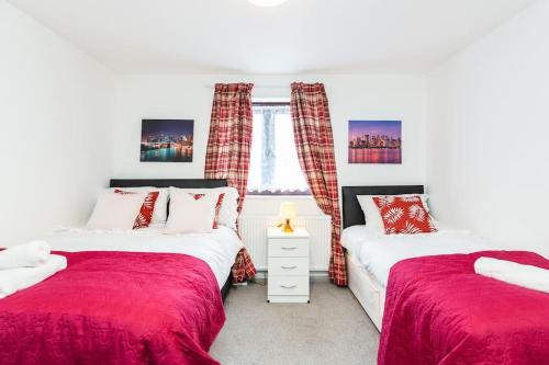a bedroom with two beds and a window at Cosy And Elegant LivingI Sleeps 5 Dagenham I Super Fast WiFi Free parking in Goodmayes