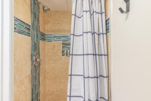 a shower with a blue and white shower curtain at Kona Islander Inn 112 in Kailua-Kona