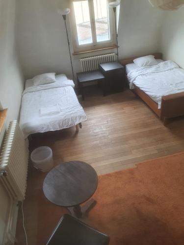 a small room with two beds and a table at Sonnegg Guest Rooms Inh M Bisegger in Zürich