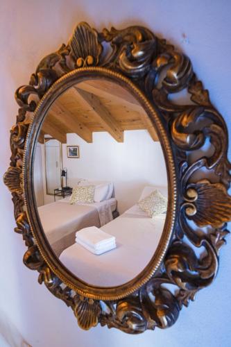 a mirror on a wall with a bed in a room at Casa Agatha Lenno- luxury air conditioned village home by Italian Apartments in Lenno