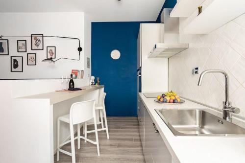 a kitchen with a sink and a blue wall at Vaticano & Villa Pamphilj Studio in Rome