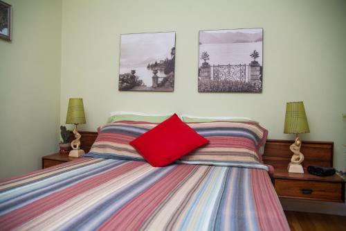 a bedroom with a bed with a red pillow on it at Maison Des Jardins B & B in Montréal