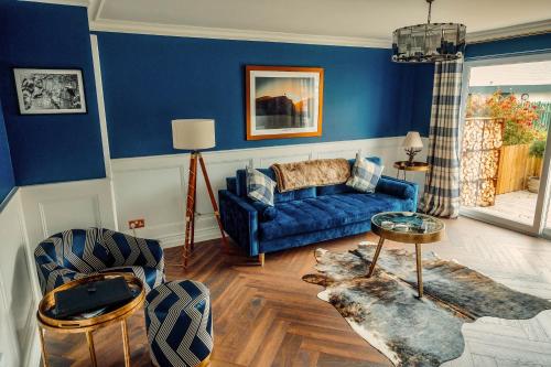 sala de estar con paredes azules y sofá azul en The Hikers House en Newcastle