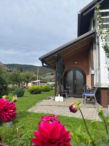a house with a yard with flowers in the foreground at Kuća za odmor Sanja in Kupres