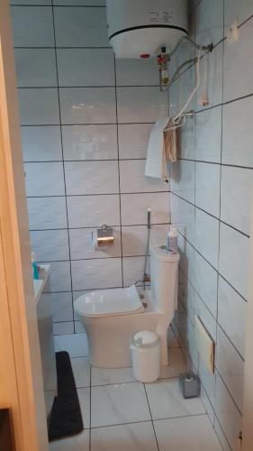 a white bathroom with a toilet and a sink at The FFG House - Appartements meublés Douala Cite des palmiers, Bonamoussadi in Douala