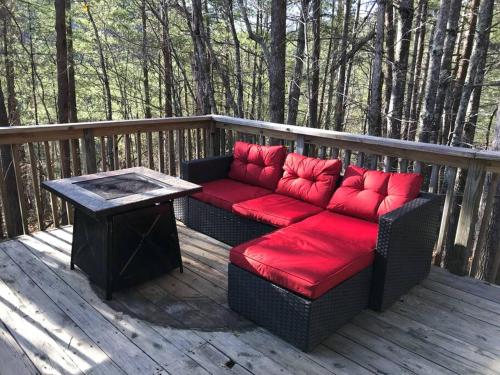 a couch with red pillows sitting on a deck at R&R Retreat in Sunshine