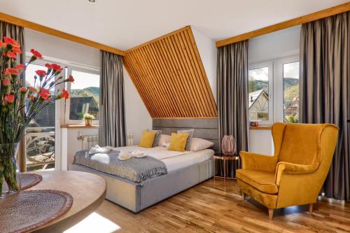 sypialnia z łóżkiem i krzesłem w obiekcie Rezydencja Skibówki w Zakopanem