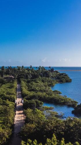 an island in the ocean with trees and water at Tatajuba Hostel Casa Pascual in Tatajuba