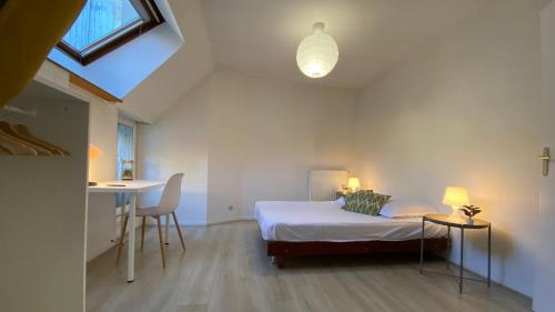 Schlafzimmer mit einem Bett, einem Tisch und einem Schreibtisch in der Unterkunft Joyau caché nivernais in Nevers