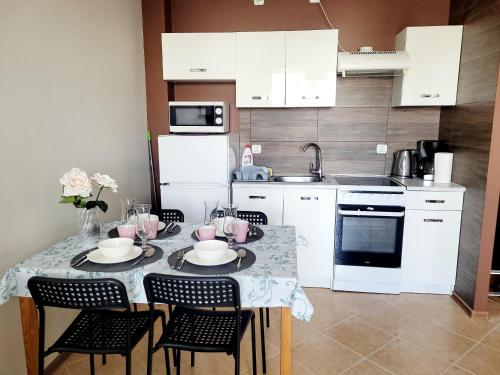 Apartament Prima في ريدا: مطبخ مع طاولة مع كراسي ومغسلة