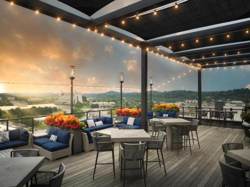 a patio with tables and chairs on a deck with a view at Hyatt Place Knoxville/Downtown in Knoxville