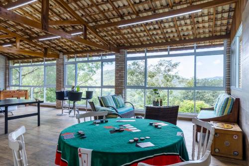 マイリポランにあるChácara 8 suítes Piscina Churrasqueira 40min de SPのテーブルと椅子と窓のある部屋