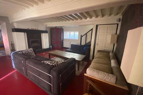 ein Wohnzimmer mit einem Sofa und einem Tisch in der Unterkunft Villa du Cerney - Lac des Settons in Moux-en-Morvan
