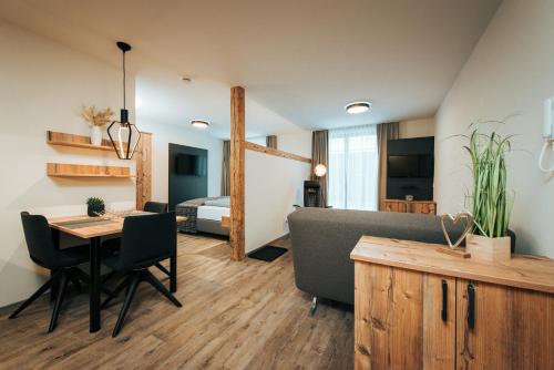 a living room with a table and a bedroom at Living Mountain Tannheim in Tannheim