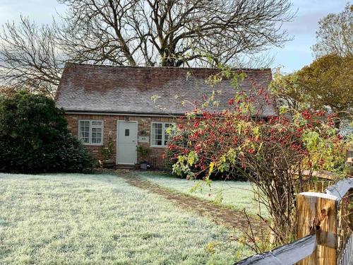 una pequeña casa de ladrillo con una puerta blanca en The Piggery, a perfect country hideaway, en Crowhurst