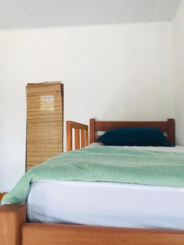 a bedroom with a bed with a wooden head board at Natal Chalés Nova Caraiva in Caraíva