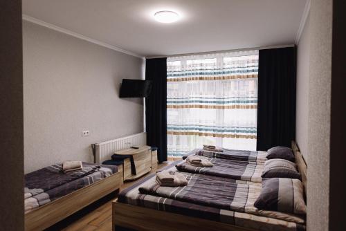 two beds in a room with a window at Brooklyn 2 in Yablunytsya