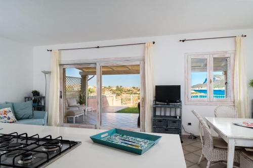 a kitchen with a stove and a living room at S'Abba e Sa Pedra in Golfo Aranci