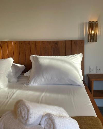 a large white bed with white sheets and pillows at Casa Rosa Atins in Atins