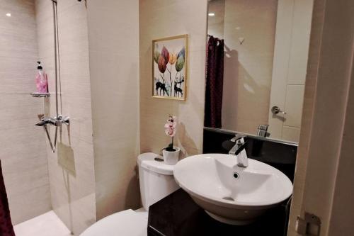 y baño con aseo blanco y lavamanos. en Lovely condo near NAIA terminal 3, en Manila