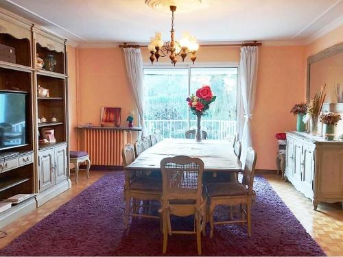 a dining room with a table with chairs and a television at Grain de blé Location in Toury