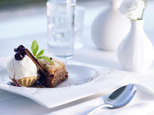 a white plate with a piece of dessert on a table at Hotel Du Lac Congress Center & Spa in Ioannina