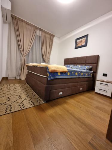Un dormitorio con una cama y suelo de madera. en Fantastic new centre apartment, en Podgorica