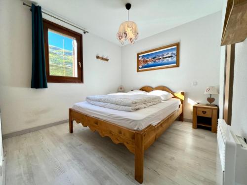 1 dormitorio con cama y ventana en Appartement Flumet, 3 pièces, 6 personnes - FR-1-505-88, en Flumet