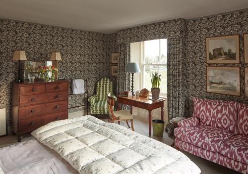 a bedroom with a bed and a couch and a desk at North Farm in Walworth