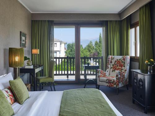 a hotel room with a bed and a balcony at Hotel Du Lac Congress Center & Spa in Ioannina