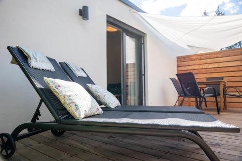 a black chair sitting on a deck with pillows at Spokojnia in Lubrza