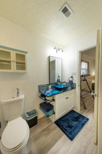 a bathroom with a toilet and a blue sink at Keepin' It Salty! in Surfside Beach