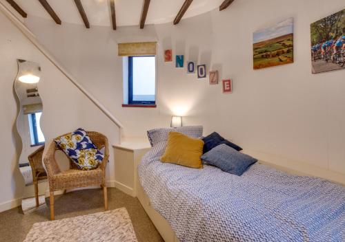 a bedroom with a bed and a chair at The Old Windmill in Kirkbymoorside