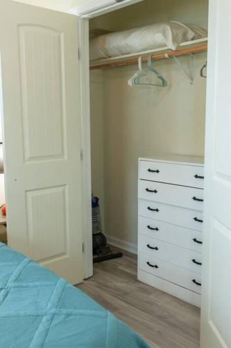 a bedroom with a closet with a bed and a dresser at Keepin' It Salty! in Surfside Beach