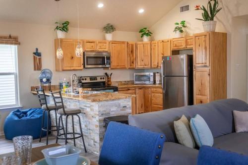 a kitchen with wooden cabinets and a blue couch at Keepin' It Salty! in Surfside Beach