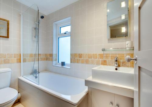 een badkamer met een bad, een wastafel en een toilet bij Maisies Place in Brighton & Hove