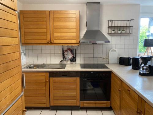 a kitchen with wooden cabinets and a stove top oven at SauerlandBlick in Altena