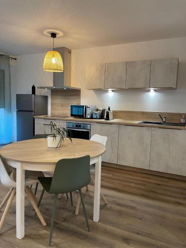 une cuisine avec une table et des chaises dans une pièce dans l'établissement L’Oradou - Neuf - Tout équipé - Parking - Wifi, à Clermont-Ferrand